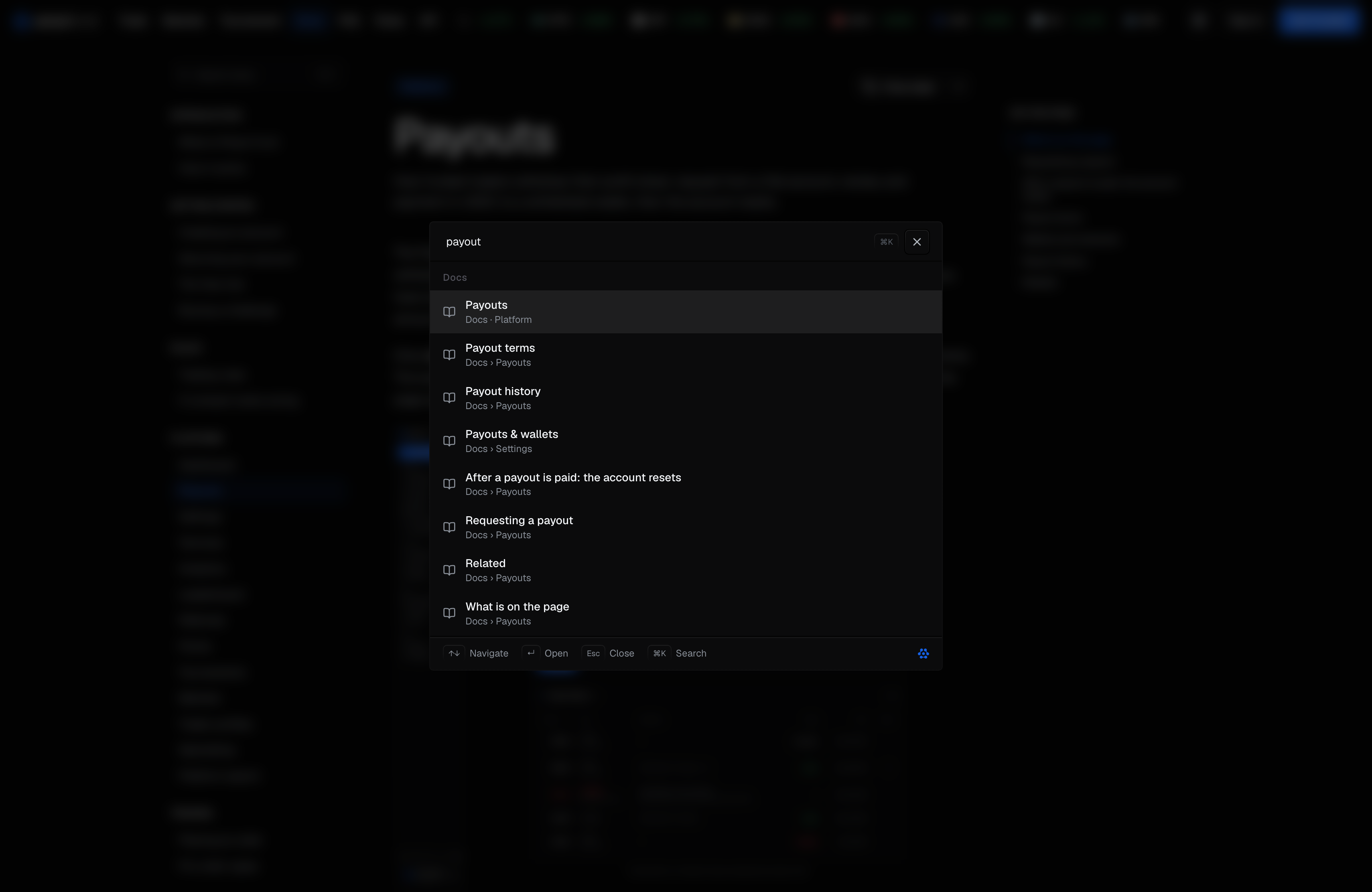 The same panel open over a docs page, with payout typed in the box and every result under a single Docs heading: the Payouts page, then headings inside it, each row showing a title and one context line, with the key hints along the bottom.